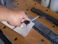 One of the drilled holes to attach the dovetail bar being tapped with threads.