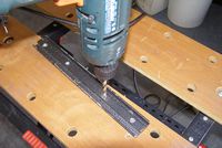 Matching holes drilled down the middle of the dovetail bar to attach it to the dovetail plate.